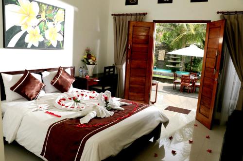 努沙杜瓦Kubu Garden Suites & Villas Nusa Dua的一间卧室配有带毛巾的床
