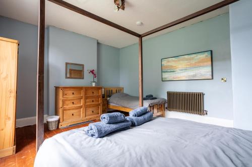 Clayton WestHolmfield House的一间卧室配有一张带蓝色毛巾的床