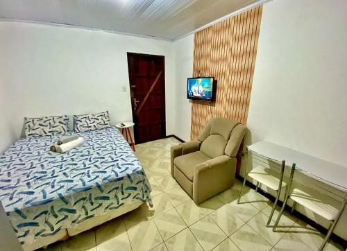 萨尔瓦多Kitnet Completa Centro Histórico的一间卧室配有一张床、一把椅子和电视。