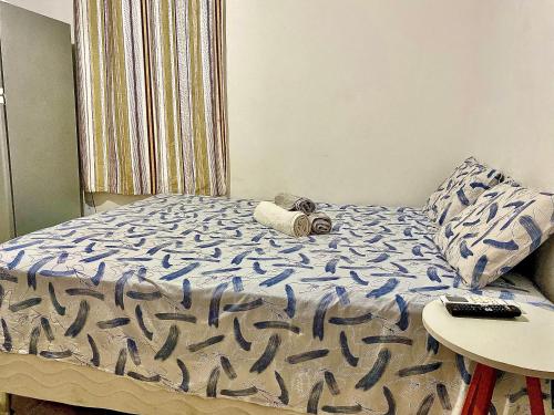 萨尔瓦多Kitnet Completa Centro Histórico的一张带蓝色棉被和一张桌子的床
