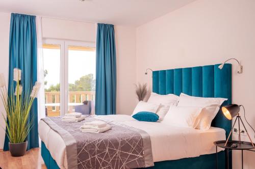 波尔Hotel SOL的一间卧室配有一张带蓝色窗帘的大床