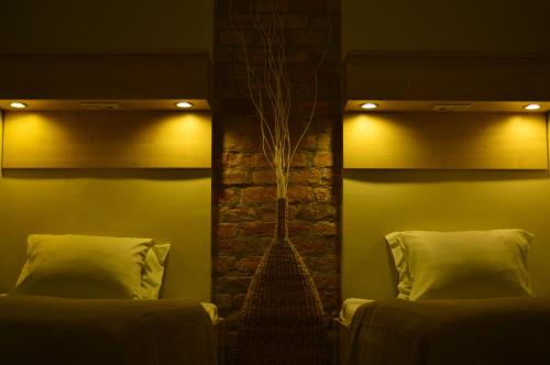 布达佩斯珊特罗姆斯酒店的一间卧室设有两张床和砖墙