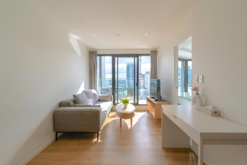 奥克兰Apartment with Brilliant views in Auckland CBD的客厅配有沙发和桌子