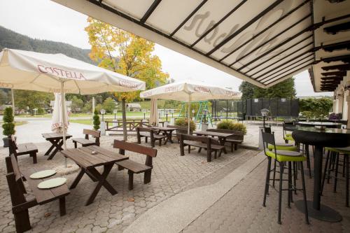 拉多夫吉卡索贝克罗纳旅馆的一个带木桌、椅子和遮阳伞的庭院