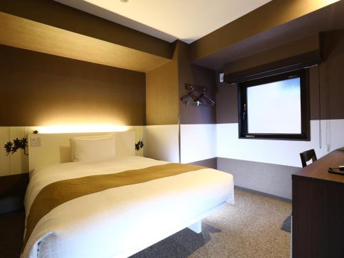 东京上野御徒町永国国际精选酒店的一间卧室设有一张大床和一个窗户。