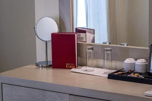 阿吉亚玛丽娜伊拉多酒店的一个带镜子的柜台、一本书和眼镜