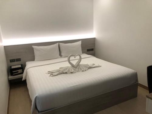 曼谷Thana Wisut Hotel - SHA Plus的一间拥有心灵装饰的床的房间