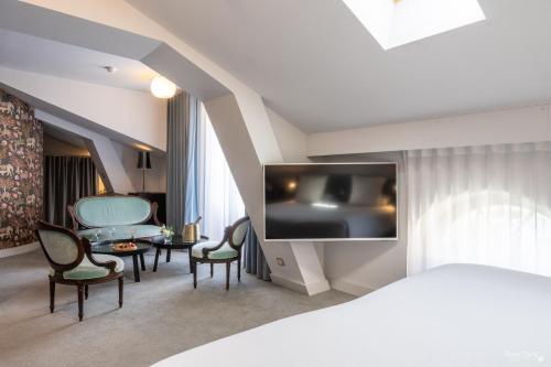 拉罗谢尔Hôtel La Monnaie Arty & Spa的酒店客房带一张床、一张桌子和椅子