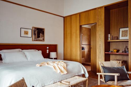 博尼约Capelongue, a Beaumier hotel & Spa的一间卧室配有一张大床和一把椅子