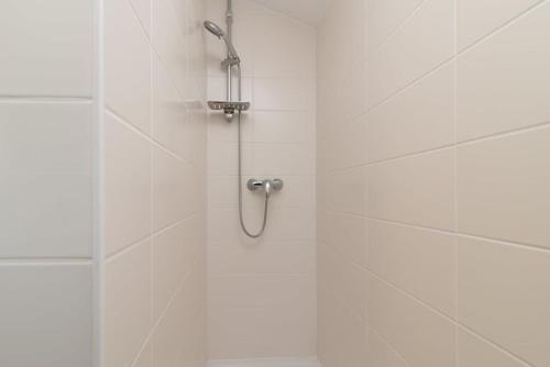 特罗吉尔Apartmani Grga的浴室铺有白色瓷砖,设有淋浴。