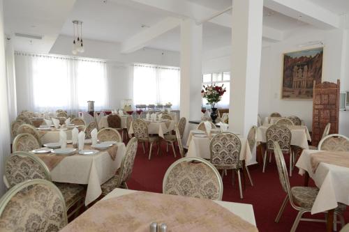 耶路撒冷耶路撒冷里沃利酒店的用餐室配有白色的桌椅和白色的桌椅