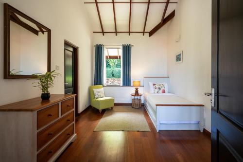 哈顿Camellia Hills的一间卧室配有一张床、一个梳妆台和一扇窗户。