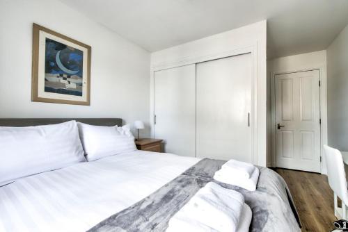 爱丁堡GuestReady - Stylish Apt w/ Parking near Edinburgh的白色卧室配有一张带白色枕头的大床