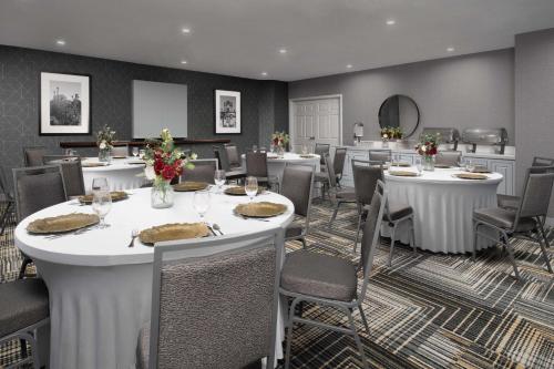 圣安东尼奥圣安东尼奥河滨/市区希尔顿惠庭套房酒店的用餐室配有桌椅和鲜花