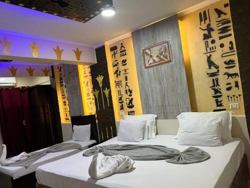 开罗Comfort Sphinx Inn的墙上有亚洲书写的两张床
