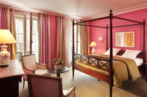 巴黎多瑙河圣日耳曼酒店的卧室配有一张床、一张桌子和椅子