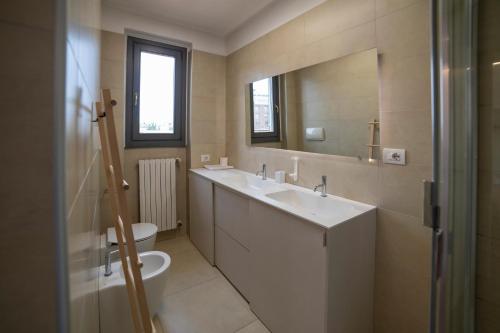 米兰VILLA FENIX MILANO的一间带水槽、卫生间和镜子的浴室