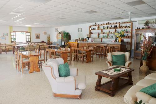 伊斯基亚赛索塔酒店的一间设有桌椅的房间和一间酒吧