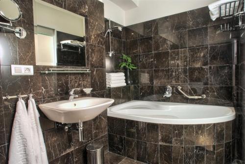 布拉格里布纳公寓酒店的一间带水槽、浴缸和镜子的浴室