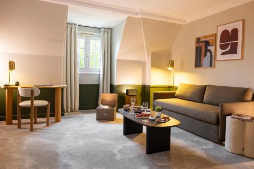 维奈Hostellerie Briqueterie & Spa Champagne的客厅配有沙发和桌子