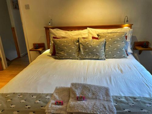 绍斯韦尔Southwell Holiday Cottage - Lavender Cottage的卧室配有一张带两个枕头的大白色床