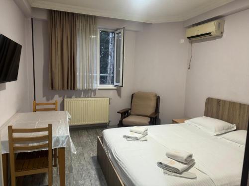 第比利斯Hotel Skib的一间设有两张床和一张桌子及椅子的房间