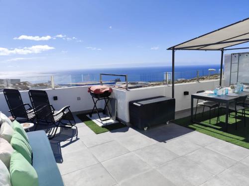 圣克鲁斯-德特内里费Ático Micaela. Terraza y vistas的一个带桌椅的海景屋顶露台