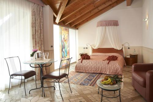 奥尔塔圣朱利奥拉布索拉酒店的卧室配有一张床和一张桌子及椅子