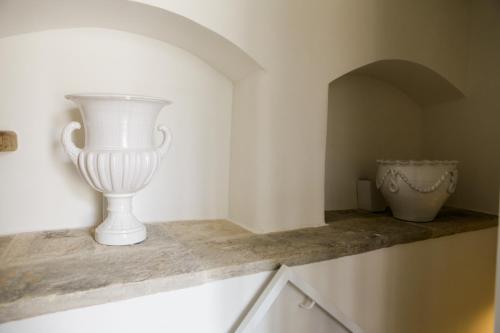 鲁沃迪普利亚La Puglia di Claudia的坐在柜台上的白色花瓶