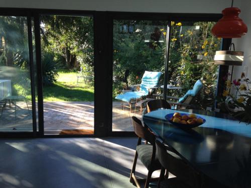雷泽La Maison Bleue的一间带玻璃桌椅的用餐室和一个庭院