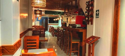 马丘比丘Amakonkay Machupicchu的餐厅设有酒吧,配有木桌和椅子