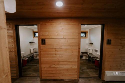 Beaver BayNorth Shore Camping Company的一间带两个卫生间和木墙的浴室