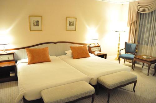 名古屋东急名古屋大饭店的酒店客房,配有两张床和椅子