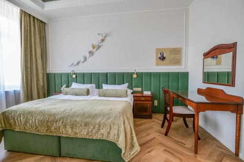 利托米什尔金星酒店的一间卧室配有一张床、一张书桌和一张书桌