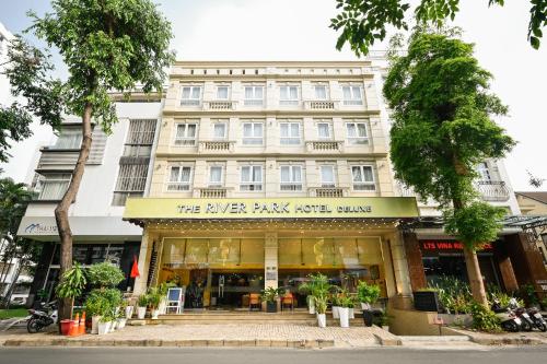 胡志明市The River Park Hotel的前面有树木的建筑前的商店