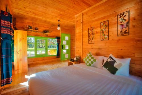 Kon Von KlaMăng Đen Treehouse Village Resort & Zipline的木制客房内的一间白色床卧室