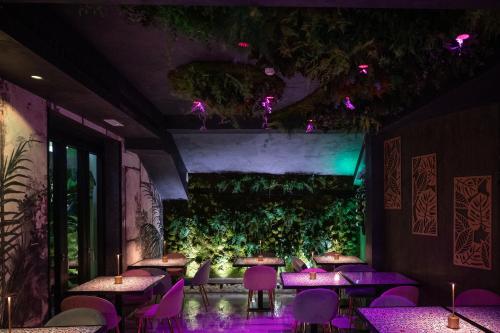 罗马卡拉维塔酒店的餐厅设有紫色桌子和绿色的墙壁