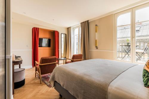 巴黎Hôtel Chamar的配有一张床和一张书桌的酒店客房