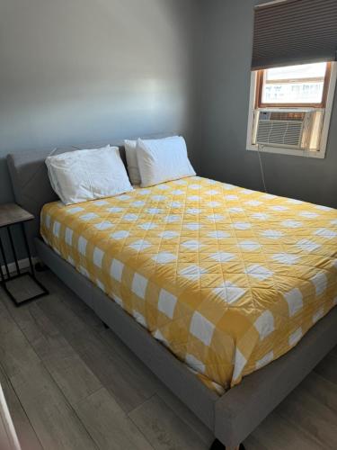 汉普顿12 Ashworth Ave suites的卧室内的一张床位,配有黄色和白色的被子