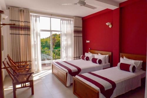 乌纳瓦图纳鲁曼萨拉望海人别墅的宿舍间的两张床,设有红色的墙壁和窗户。