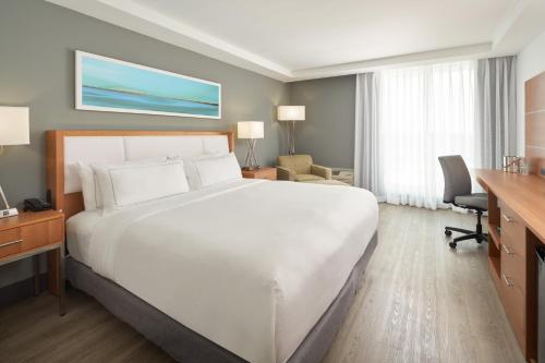 迈阿密DoubleTree by Hilton Miami North I-95的酒店客房设有一张白色大床和一张书桌