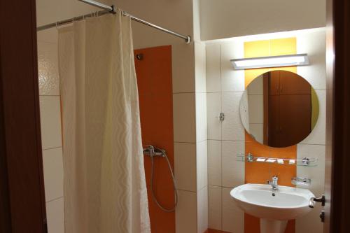 Morávka水坝酒店的浴室配有盥洗盆和带镜子的淋浴