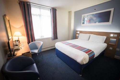 都柏林都柏林城市拉思曼斯酒店的酒店客房配有一张床、一张桌子和一把椅子。