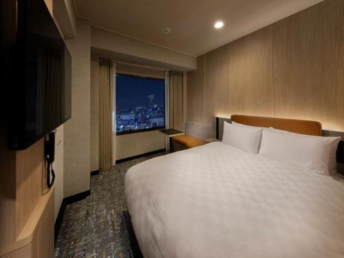 东京新宿王子大酒店的一间设有大床和窗户的酒店客房
