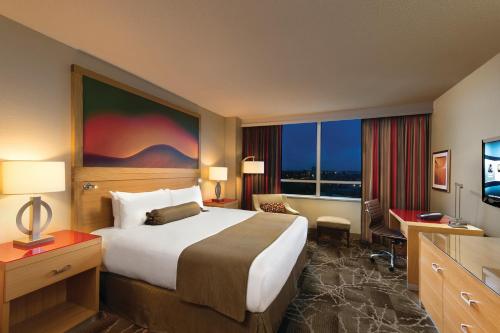 里士满River Rock Casino Hotel的酒店客房设有一张大床和一台电视。