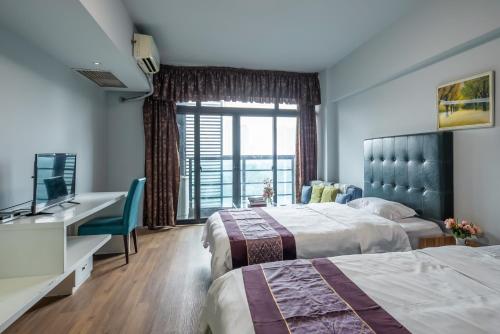 广州诺盟国际公寓广州先烈南路时代国际YOU店的酒店客房配有两张床和一张书桌