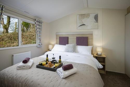 朗里奇Ribble Heights - Holiday Lodge的一间卧室配有一张床,上面放着一个食物托盘