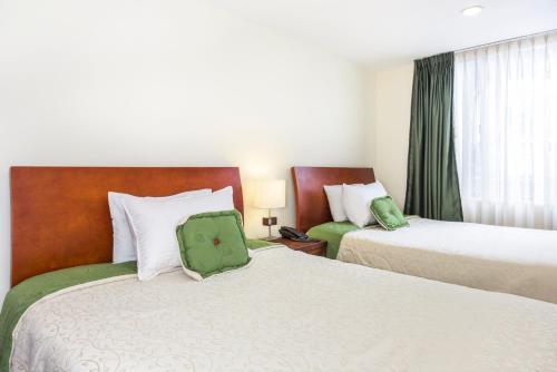 波哥大波托菲诺住宿加早餐旅馆的酒店的客房 - 带两张带绿色枕头的床