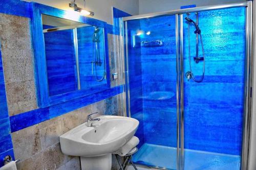 安德里亚Bed & Breakfast Paghiet的蓝色的浴室设有水槽和淋浴