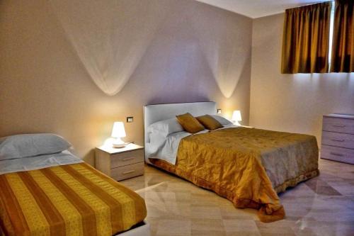 安德里亚Bed & Breakfast Paghiet的一间卧室配有两张床和两盏灯。